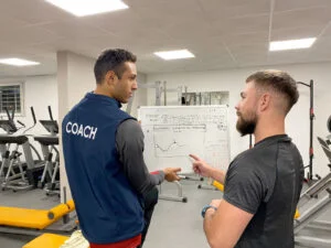 Darío explicando una planificación a un deportista en el gimnasio